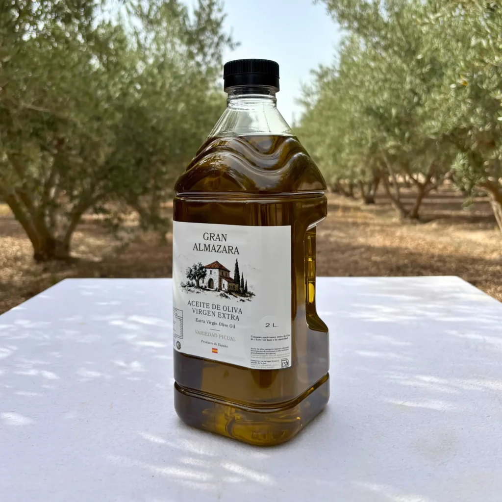 Garrafa de aceite Picual de 2 litros inclinada de lado en el olivar
