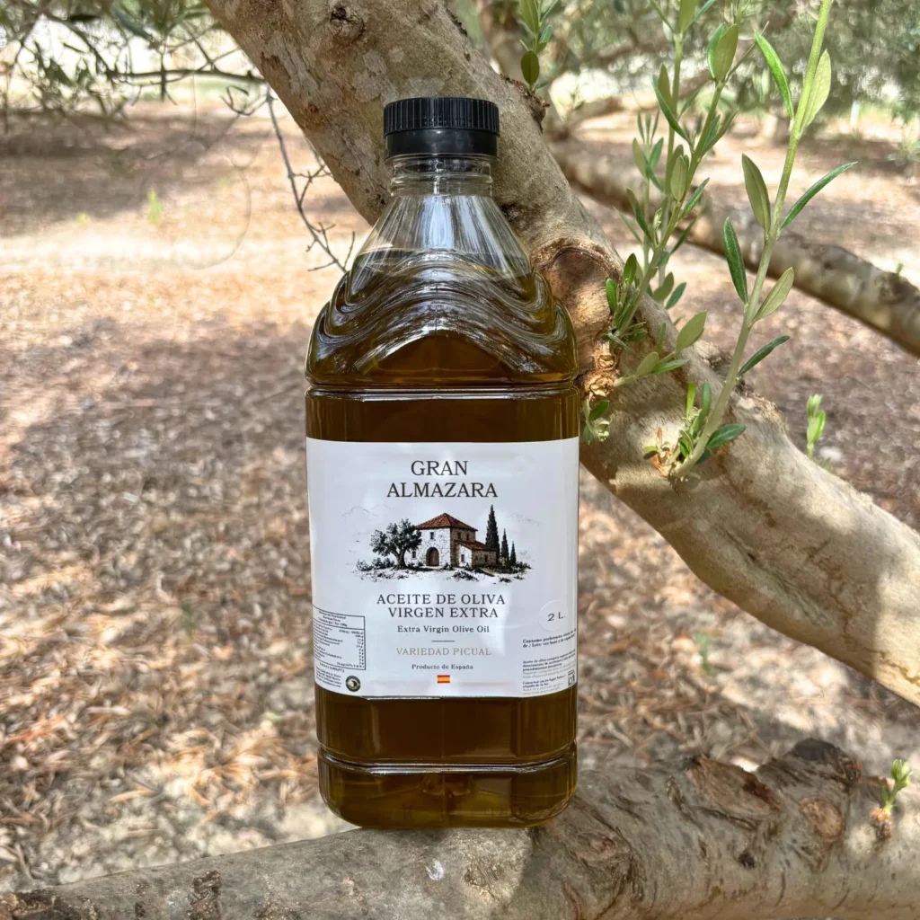 Garrafa de aceite Picual de 2 litros apoyada sobre un olivo
