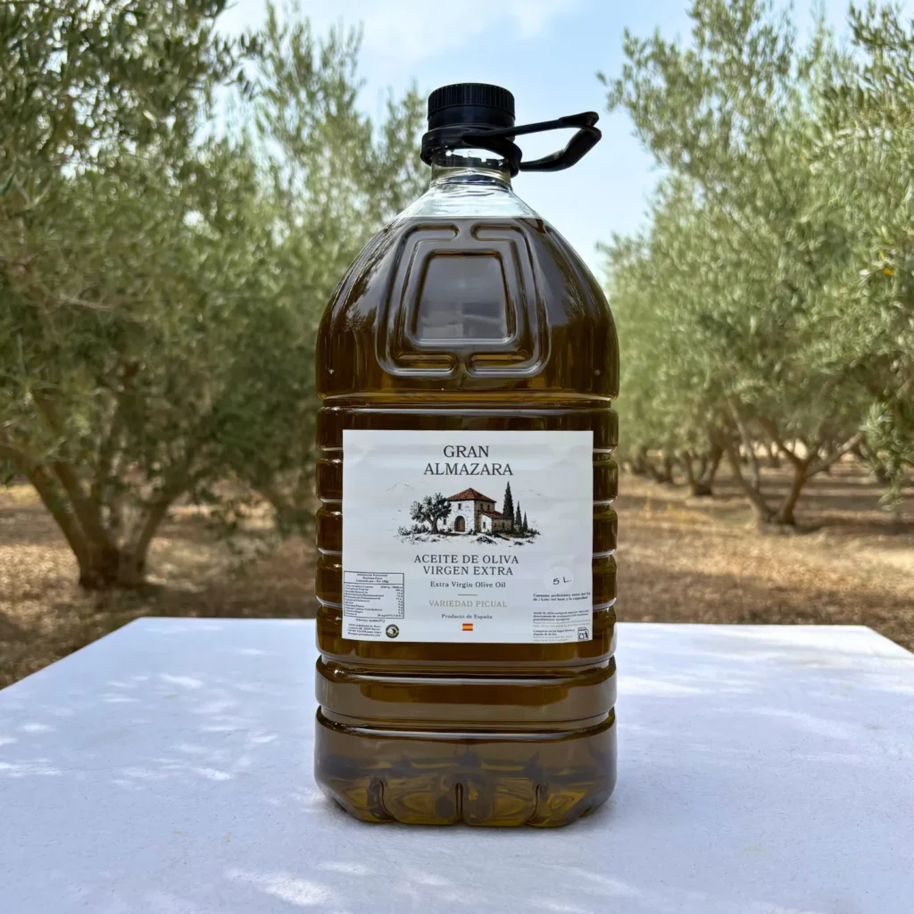 Garrafa de aceite Picual de 5 litros con la etiqueta a la vista en el olivar de Gran Almazara