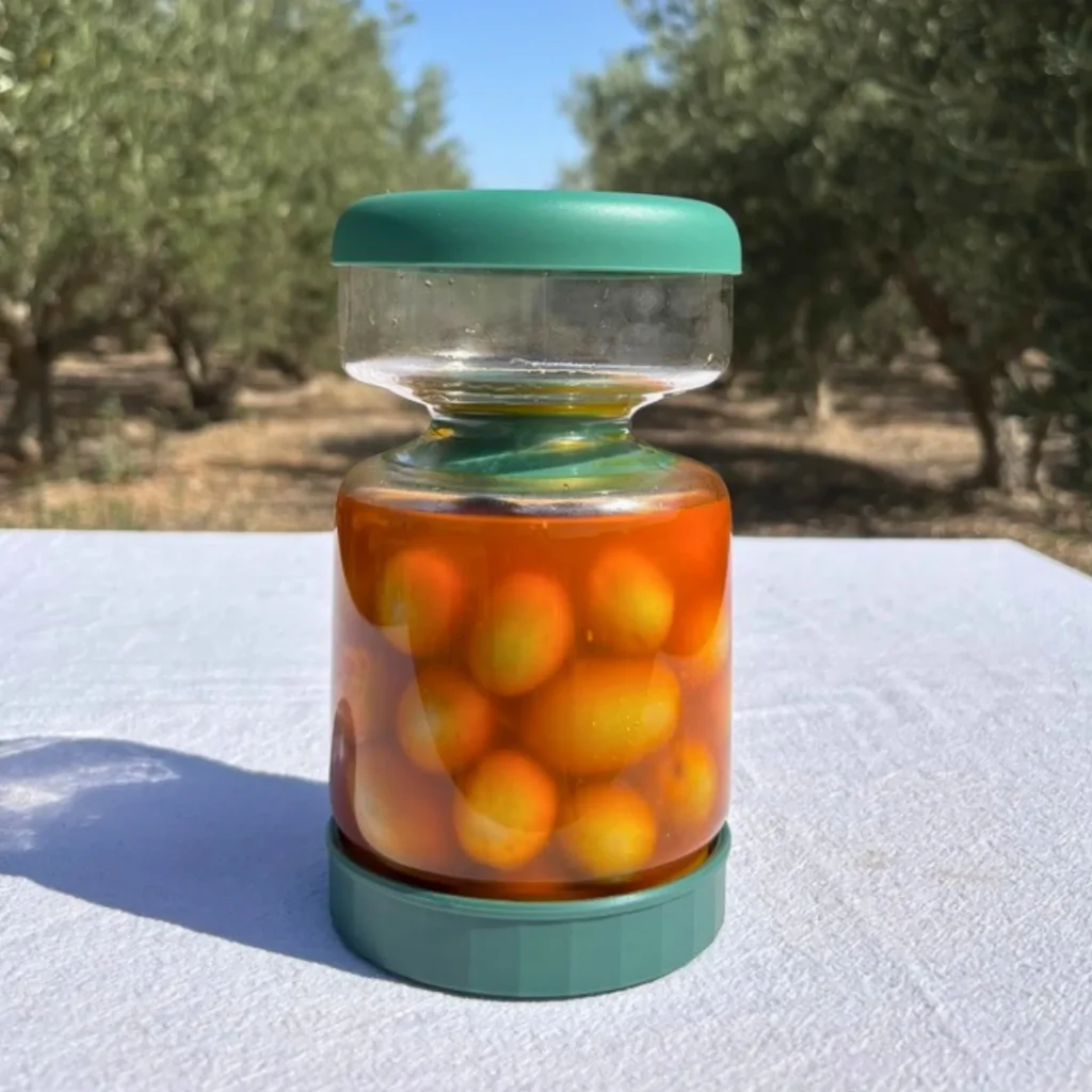Aceitunero volteado, mostrando cómo conserva las aceitunas sumergidas en su líquido