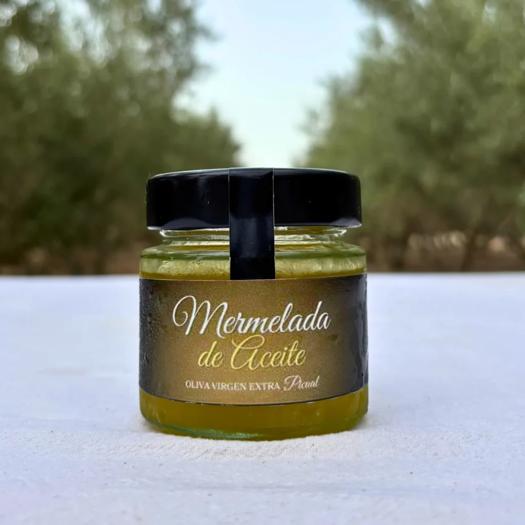 Tarro de mermelada de AOVE con la etiqueta a la vista sobre una mesa en el olivar